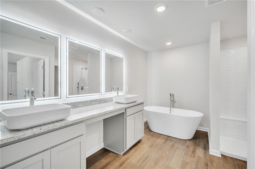 5299 Magnolia Grove Way, Unit 182 Gainesville, GA 30504 - Photo 55 of 79 a spacious bathroom with a granite countertop sink and a large mirror