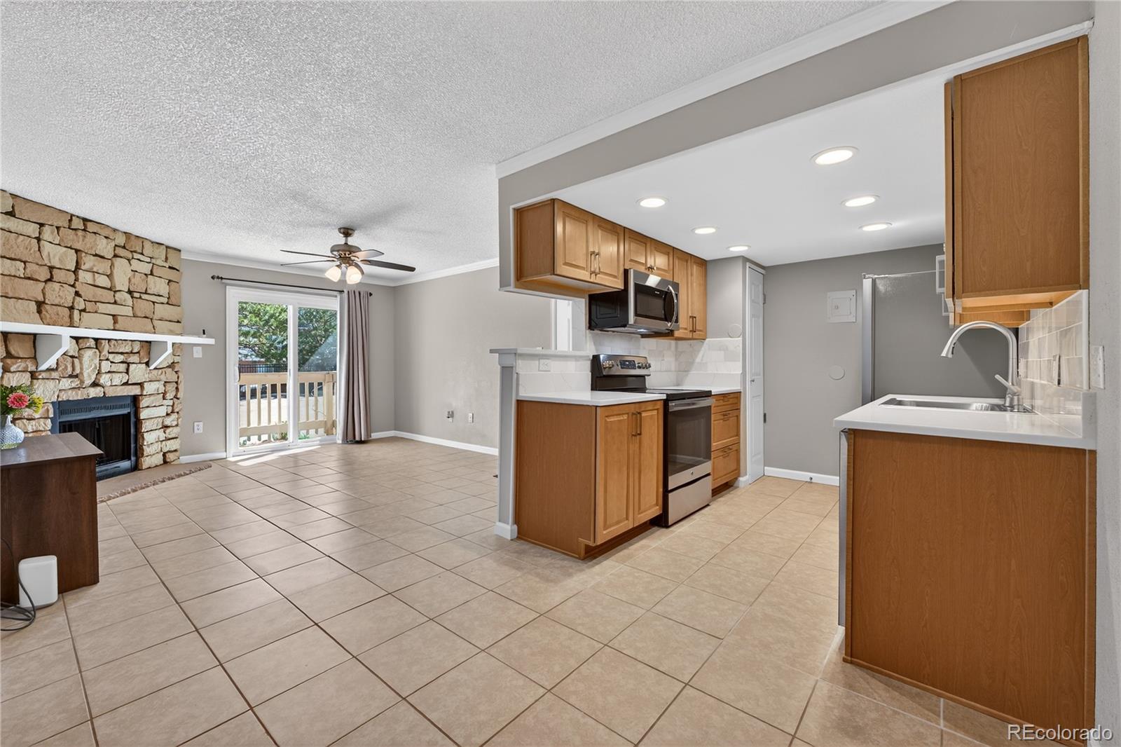 4400 South Quebec Street, Unit 101P Denver, CO 80237 - Photo 5 of 26 a kitchen with stainless steel appliances granite countertop a refrigerator oven a sink dishwasher and white cabinets with wooden floor