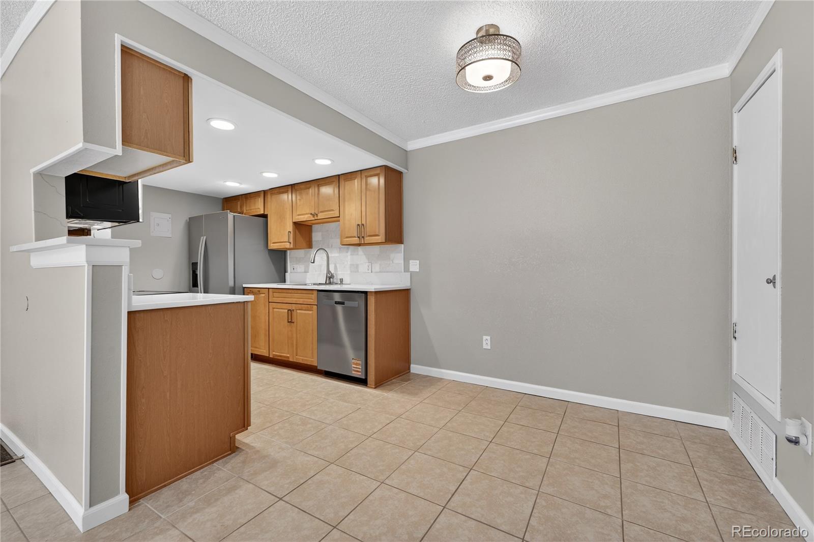 4400 South Quebec Street, Unit 101P Denver, CO 80237 - Photo 6 of 26 a kitchen with stainless steel appliances a refrigerator and a stove top oven