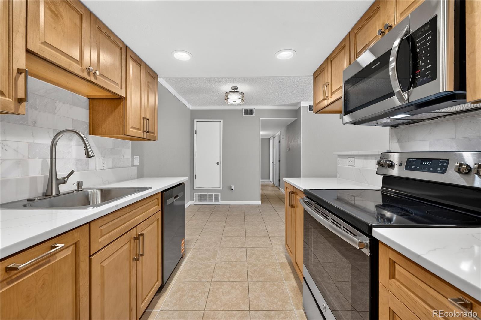 4400 South Quebec Street, Unit 101P Denver, CO 80237 - Photo 9 of 26 a kitchen with stainless steel appliances granite countertop a sink stove and cabinets