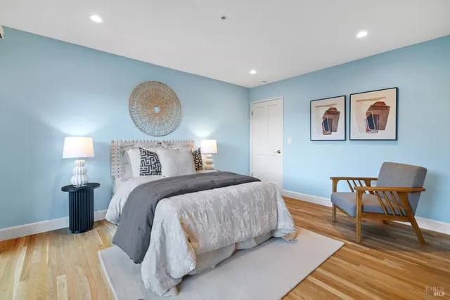 a bedroom with bed and wooden floor