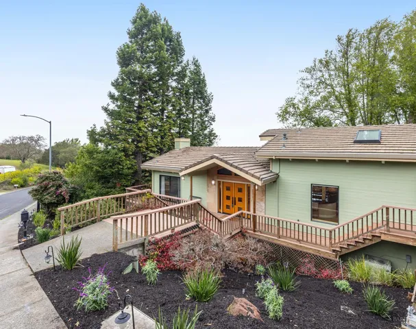a view of a house with a yard and potted plants
