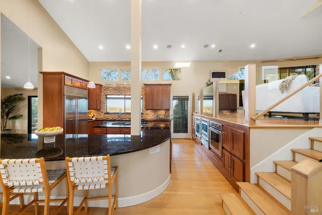 a large kitchen with stainless steel appliances kitchen island granite countertop a large counter top and stove