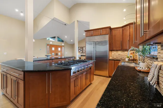 a kitchen with stainless steel appliances granite countertop a stove a refrigerator and a sink