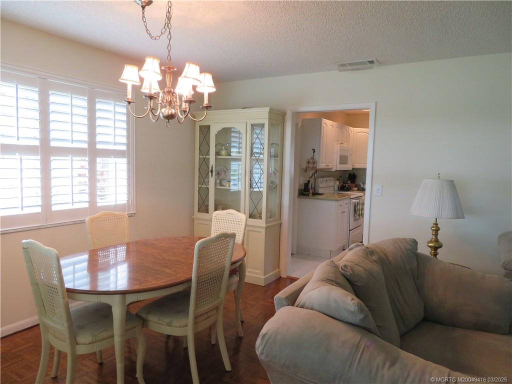 1843 Southeast Granada Lane Stuart, FL 34996 - Photo 15 of 31 a living room with furniture dining table and a chandelier