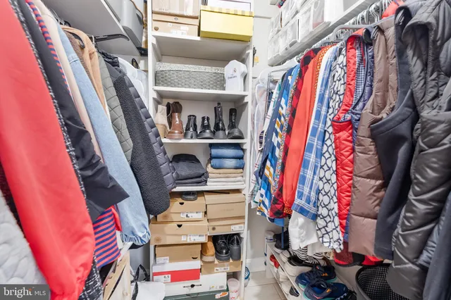 a view of walk in closet with clothes and shoes