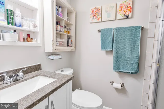 a bathroom with a sink vanity mirror and toilet