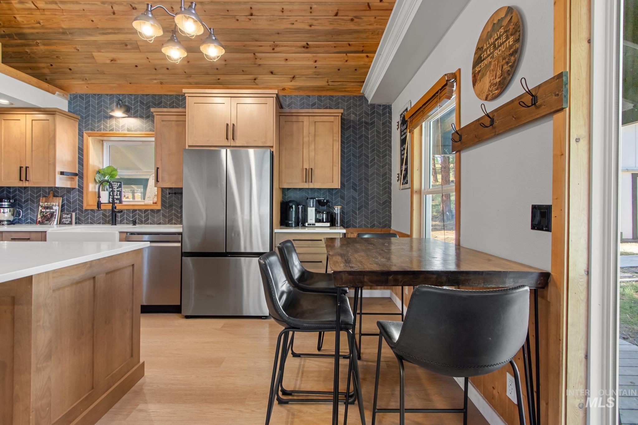 12 Meadow Creek Road Idaho City, ID 83631 - Photo 12 of 44 Kitchen featuring wood ceiling, appliances with stainless steel finishes, tasteful backsplash, light wood-style floors, and light brown cabinets