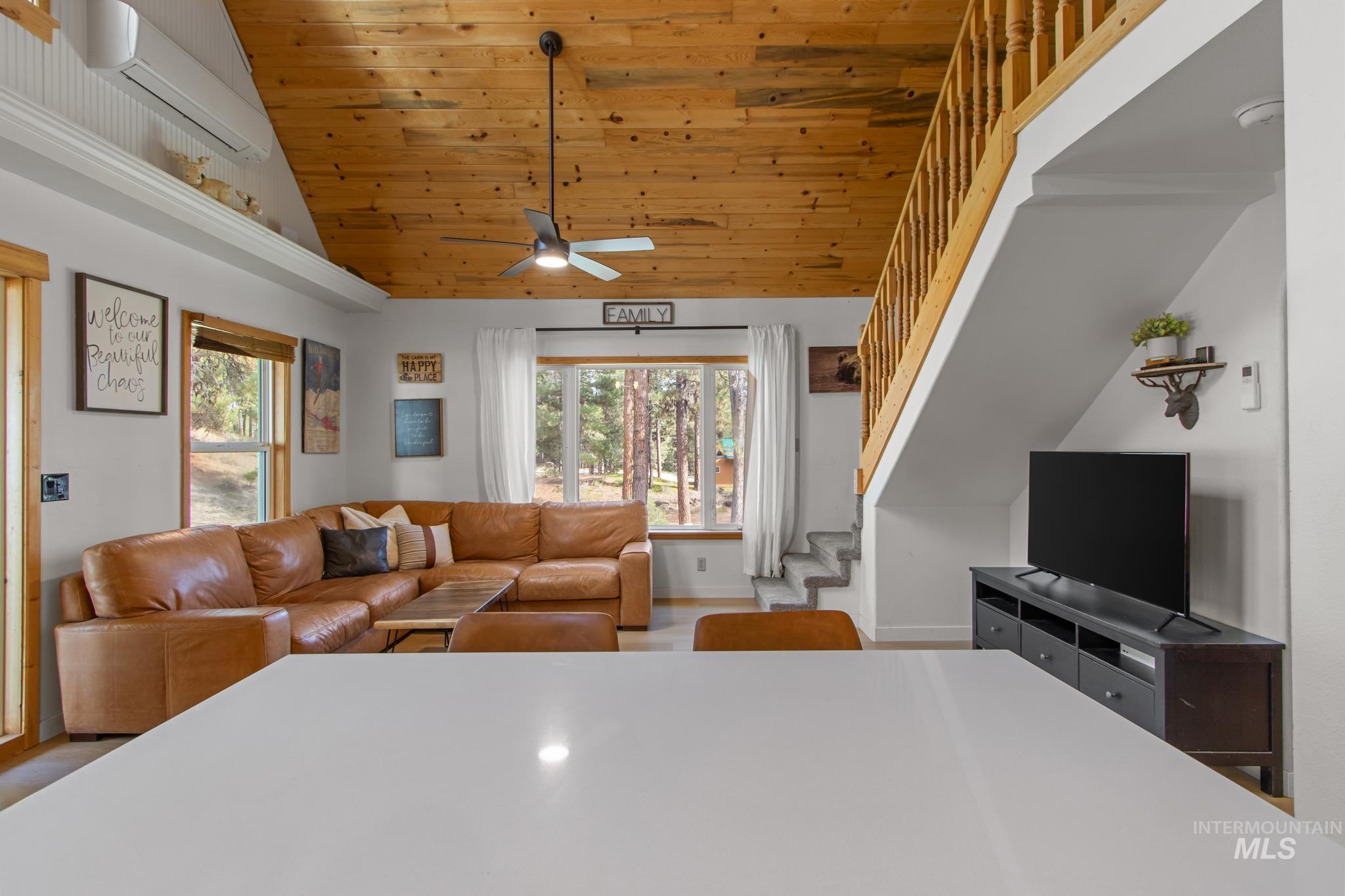 12 Meadow Creek Road Idaho City, ID 83631 - Photo 15 of 44 Living area with stairs, a wall mounted air conditioner, wood ceiling, high vaulted ceiling, and light wood finished floors