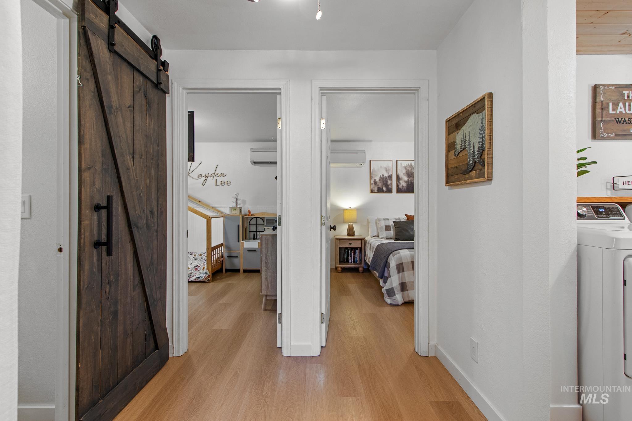 12 Meadow Creek Road Idaho City, ID 83631 - Photo 18 of 44 Hall with a barn door, light wood-style floors, and washer / clothes dryer