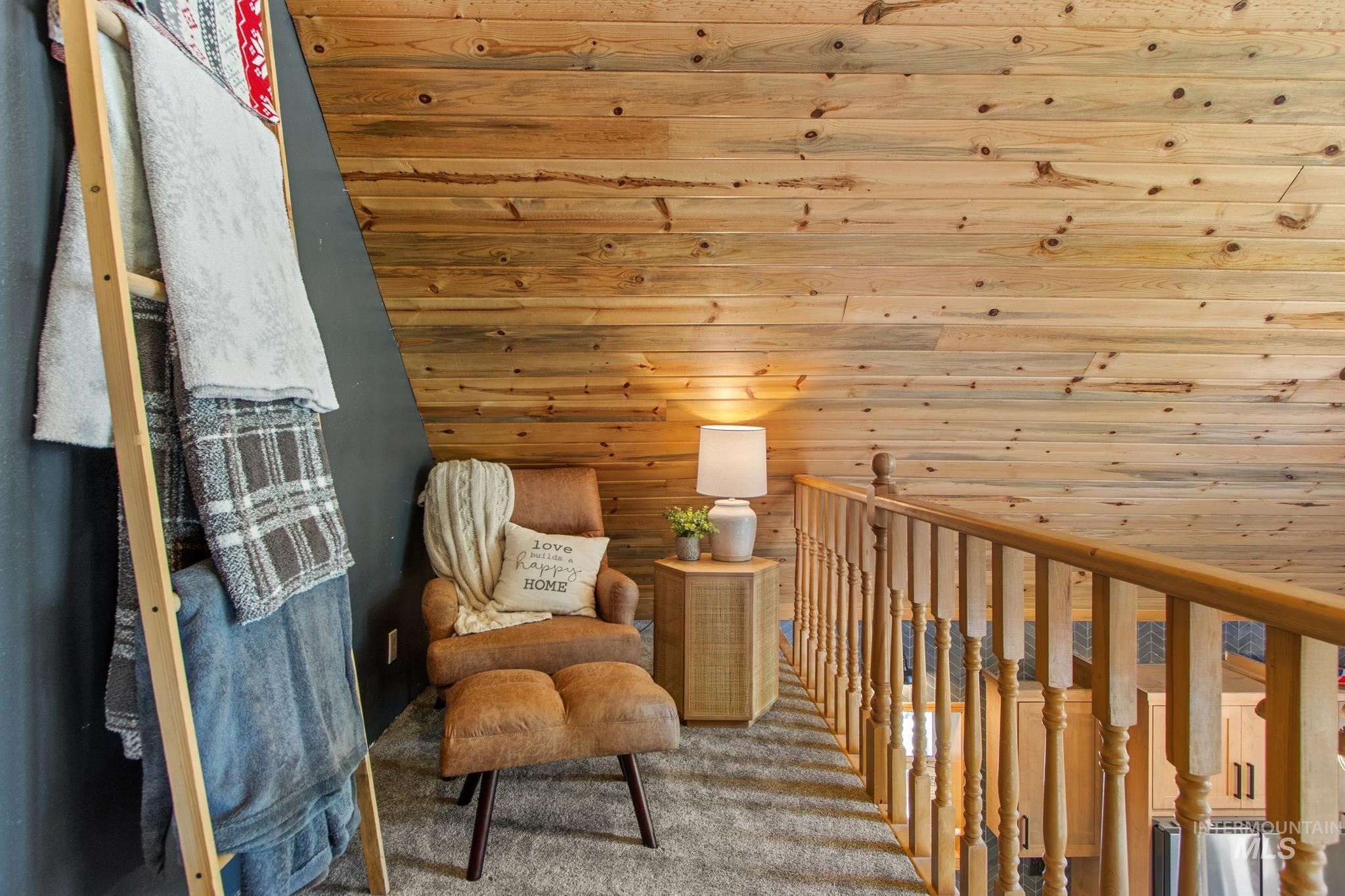 12 Meadow Creek Road Idaho City, ID 83631 - Photo 28 of 44 Living area with carpet flooring, wood walls, and an upstairs landing