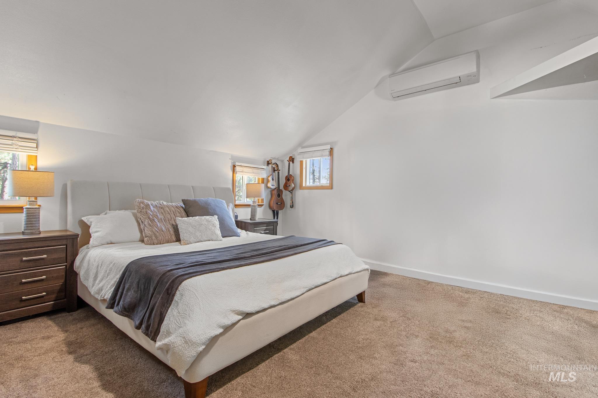 12 Meadow Creek Road Idaho City, ID 83631 - Photo 30 of 44 Bedroom with vaulted ceiling, light carpet, and a wall unit AC