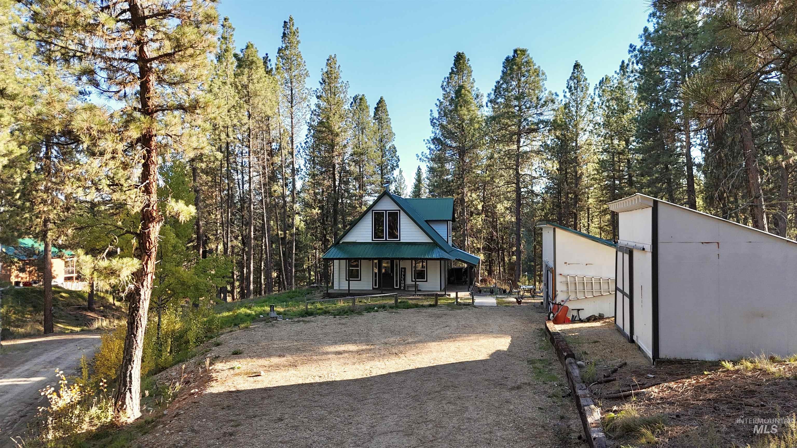 12 Meadow Creek Road Idaho City, ID 83631 - Photo 43 of 44 View of yard with covered porch, a forest view, and an outbuilding