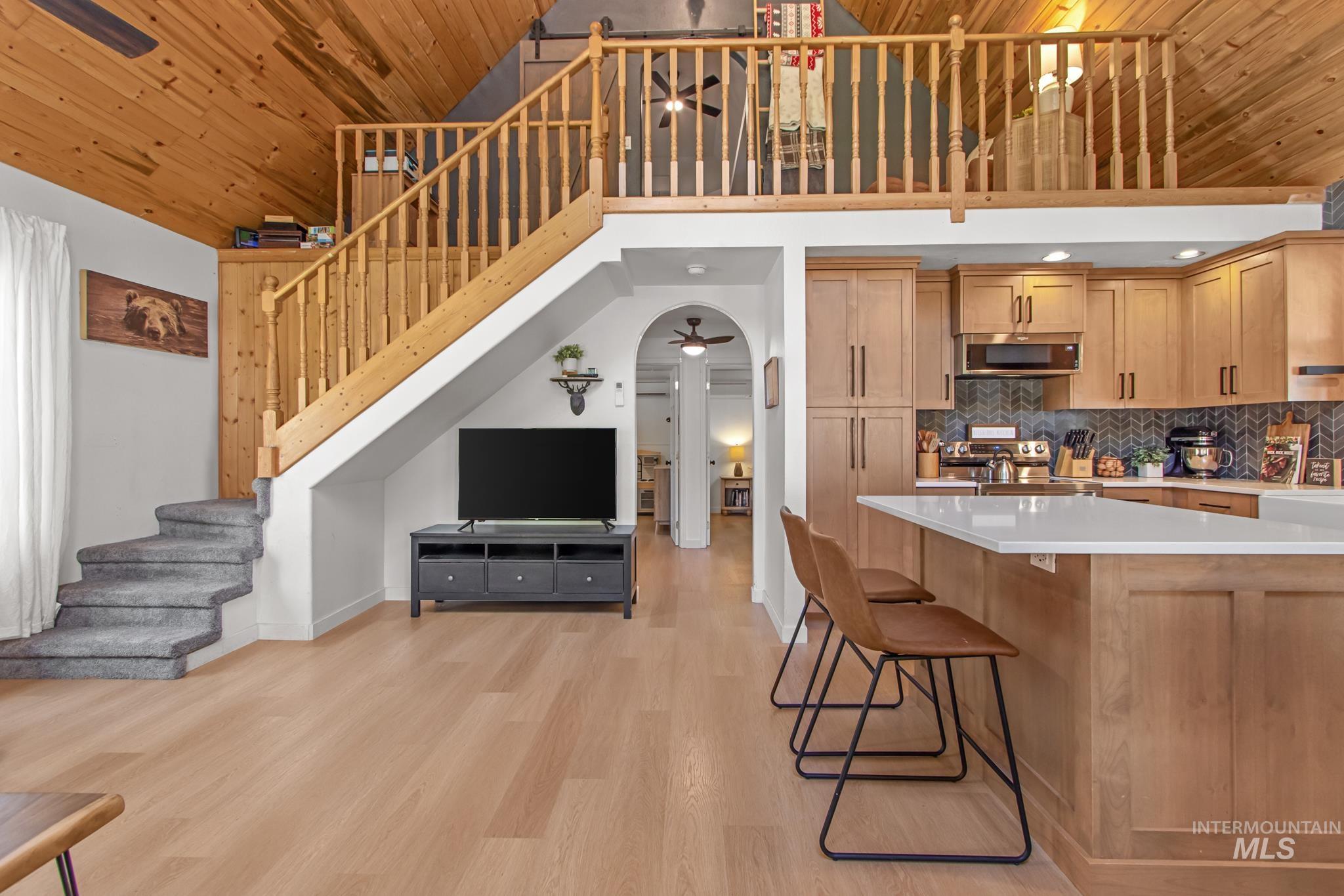 12 Meadow Creek Road Idaho City, ID 83631 - Photo 5 of 44 Kitchen featuring wooden ceiling, a ceiling fan, backsplash, a breakfast bar, and light wood-type flooring
