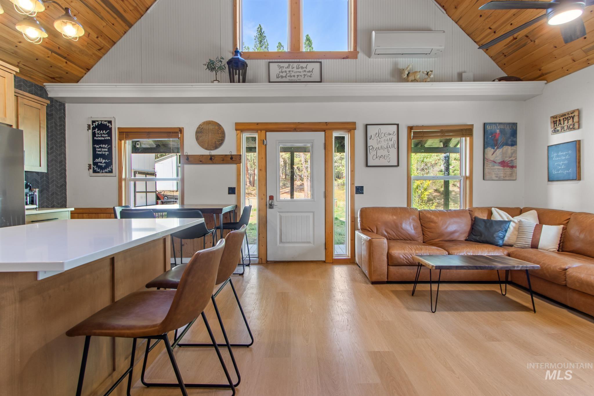 12 Meadow Creek Road Idaho City, ID 83631 - Photo 6 of 44 Living room with wood ceiling, light wood-style flooring, healthy amount of natural light, a ceiling fan, and an AC wall unit