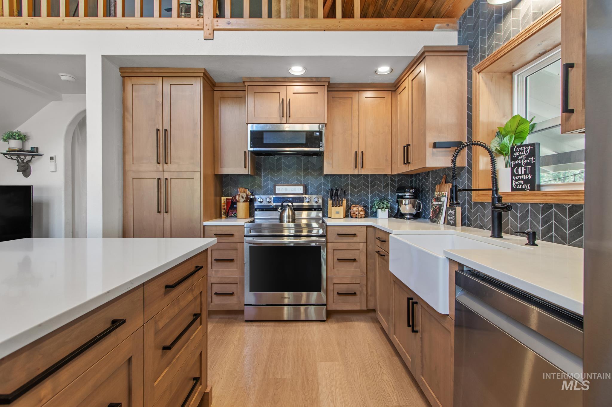 12 Meadow Creek Road Idaho City, ID 83631 - Photo 9 of 44 Kitchen featuring tasteful backsplash, stainless steel appliances, light wood-style flooring, brown cabinetry, and recessed lighting