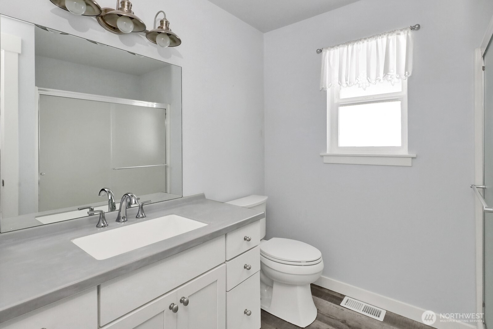 1502 Burrows Court Anacortes, WA 98221 - Photo 13 of 15 a bathroom with a granite countertop toilet a sink a mirror and a window