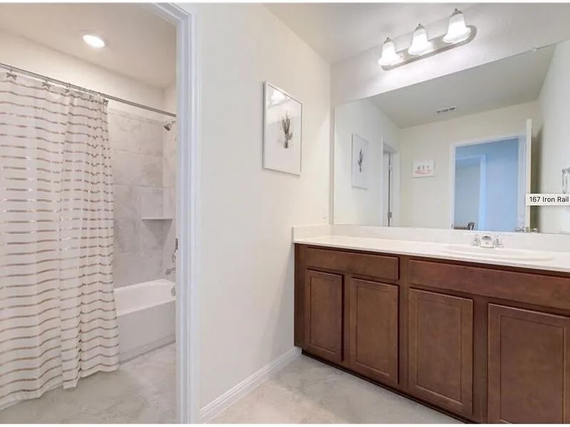 167 Iron Rail Road Dripping Springs, TX 78620 - Photo 13 of 17 Bathroom with vanity, baseboards, and shower / bath combo