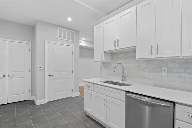 a kitchen with white cabinets and a sink