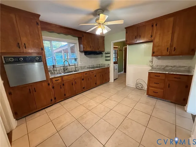 a kitchen with stainless steel appliances granite countertop a sink counter space cabinets and a large window