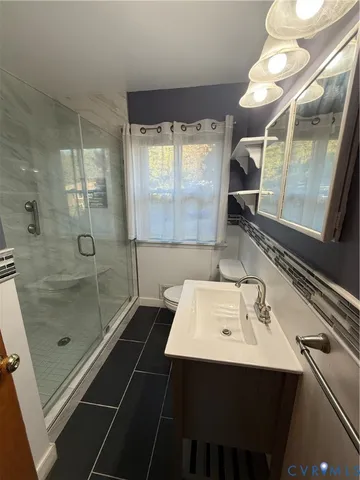 a bathroom with a sink shower and a mirror