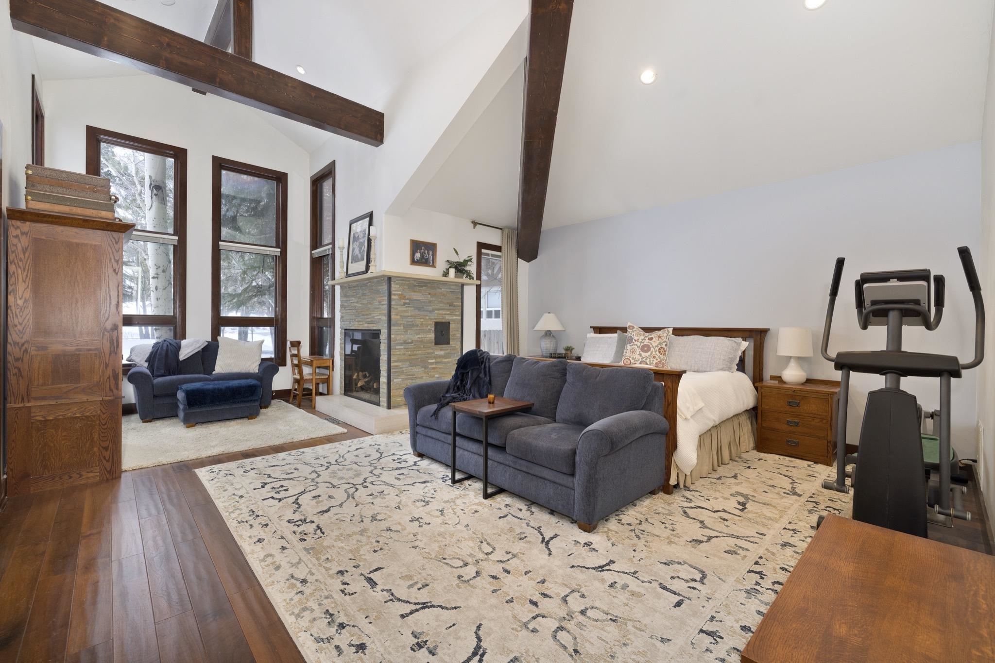 310 Ranch Road Mammoth Lakes, CA 93546 - Photo 15 of 40 Bedroom with dark wood-type flooring, high vaulted ceiling, a fireplace, beamed ceiling, and recessed lighting