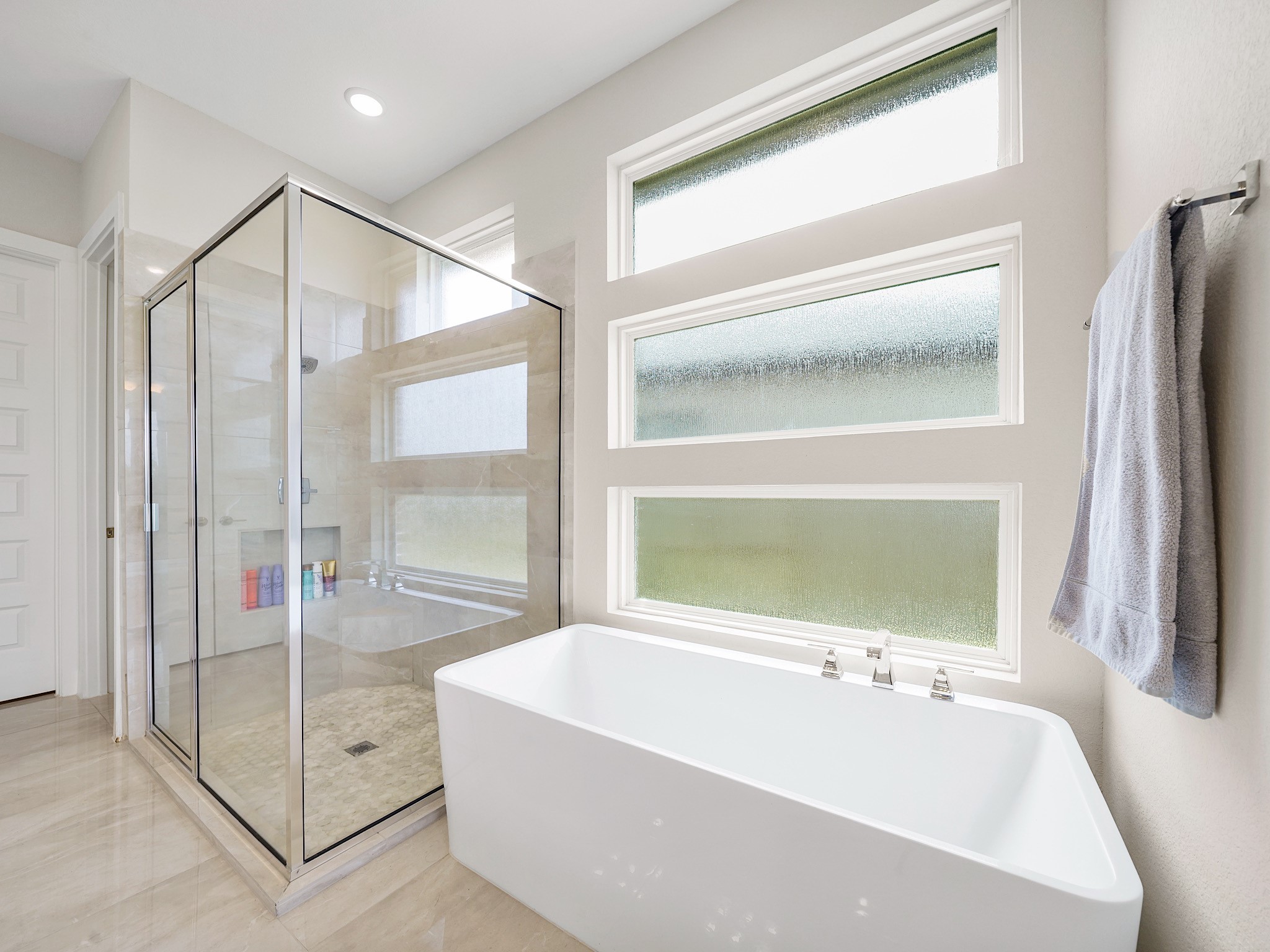 5802 Emerald Ranch Lane Fulshear, TX 77441 - Photo 26 of 45 The freestanding soaking tub and oversized glass-enclosed shower create a relaxing spa-inspired experience, perfectly complemented by the natural light and elegant finishes throughout the ensuite.