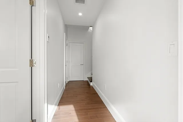 a view of a hallway with wooden floor
