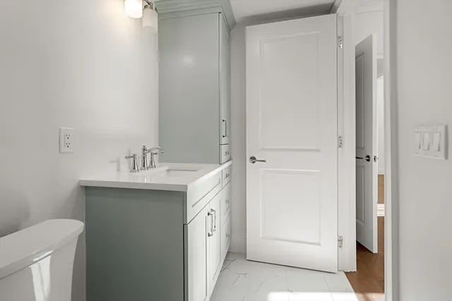 a bathroom with a sink and mirror with toilet