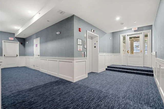 a view of a hallway with wooden cabinet