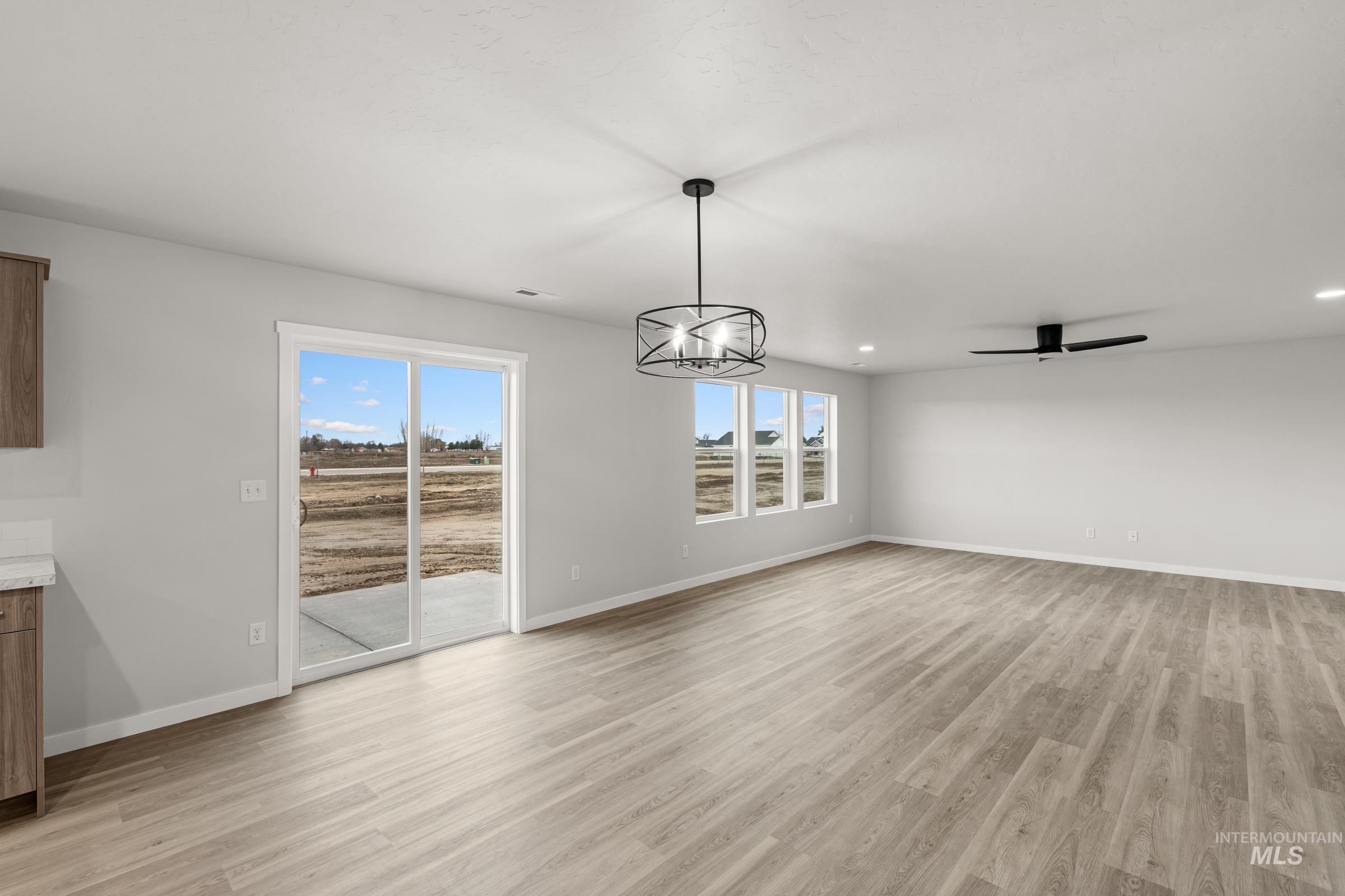 13693 Redway Court Caldwell, ID 83607 - Photo 6 of 25 Unfurnished dining area featuring light wood-type flooring and hanging lights