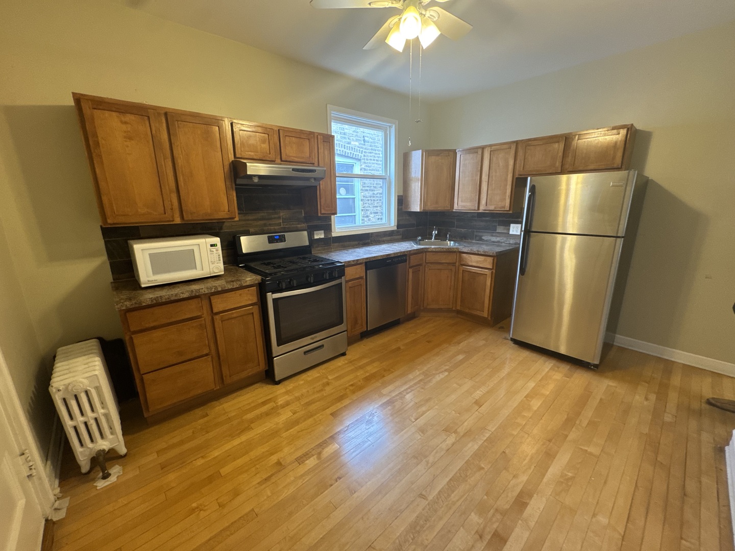 6208 North Artesian Avenue, Unit 2 Chicago, IL 60659 - Photo 11 of 14 a kitchen with a refrigerator sink and wooden cabinets
