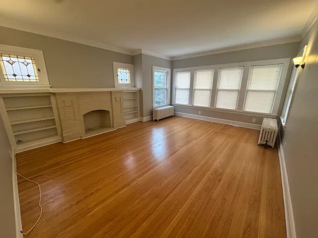 a view of a livingroom with wooden floor and a fireplace