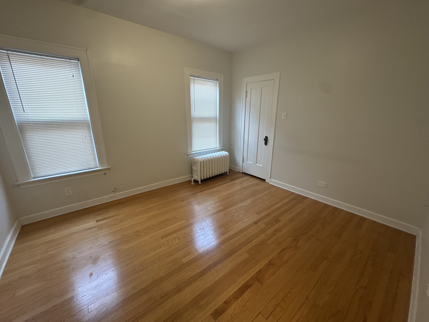 6208 North Artesian Avenue, Unit 2 Chicago, IL 60659 - Photo 7 of 14 an empty room with wooden floor and windows