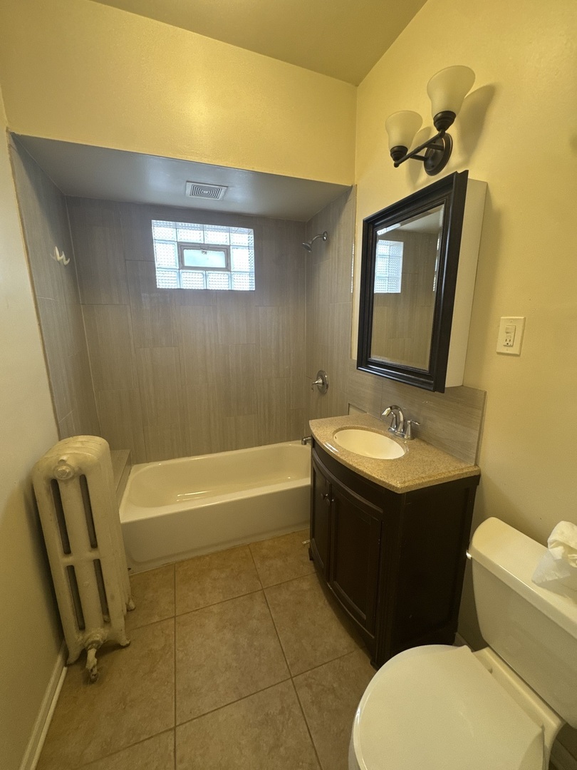 6208 North Artesian Avenue, Unit 2 Chicago, IL 60659 - Photo 10 of 14 a bathroom with a toilet sink and mirror