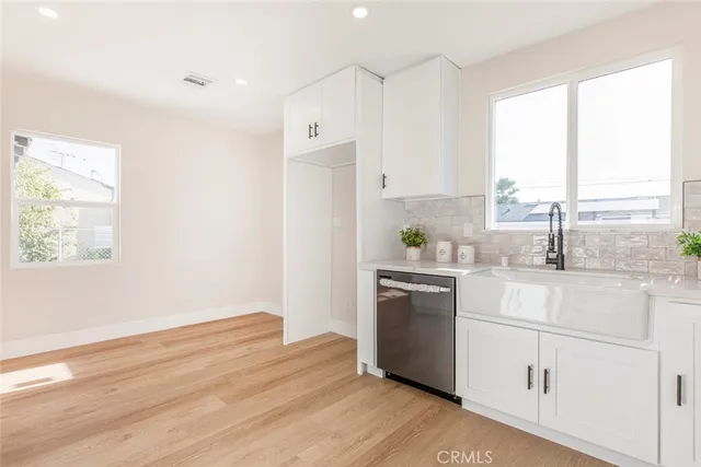 a kitchen with a white cabinets and wooden floor
