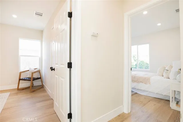 a view of a bedroom with wooden floor and a window