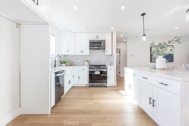 a kitchen with stainless steel appliances kitchen island granite countertop a refrigerator and a stove top oven
