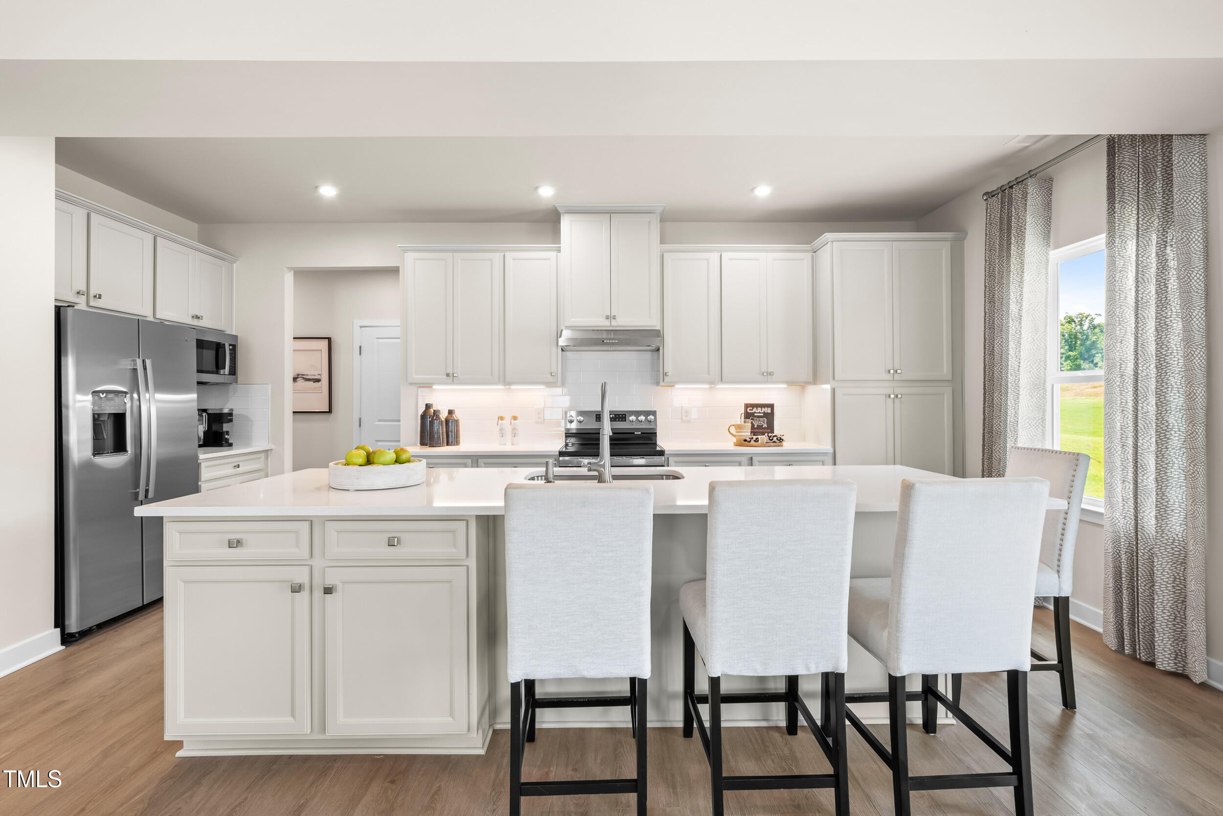 809 Walker Rdg Way Willow Spring, NC 27592 - Photo 4 of 33 a kitchen with a table chairs refrigerator and cabinets