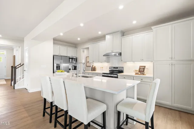 a kitchen with a table chairs refrigerator and cabinets