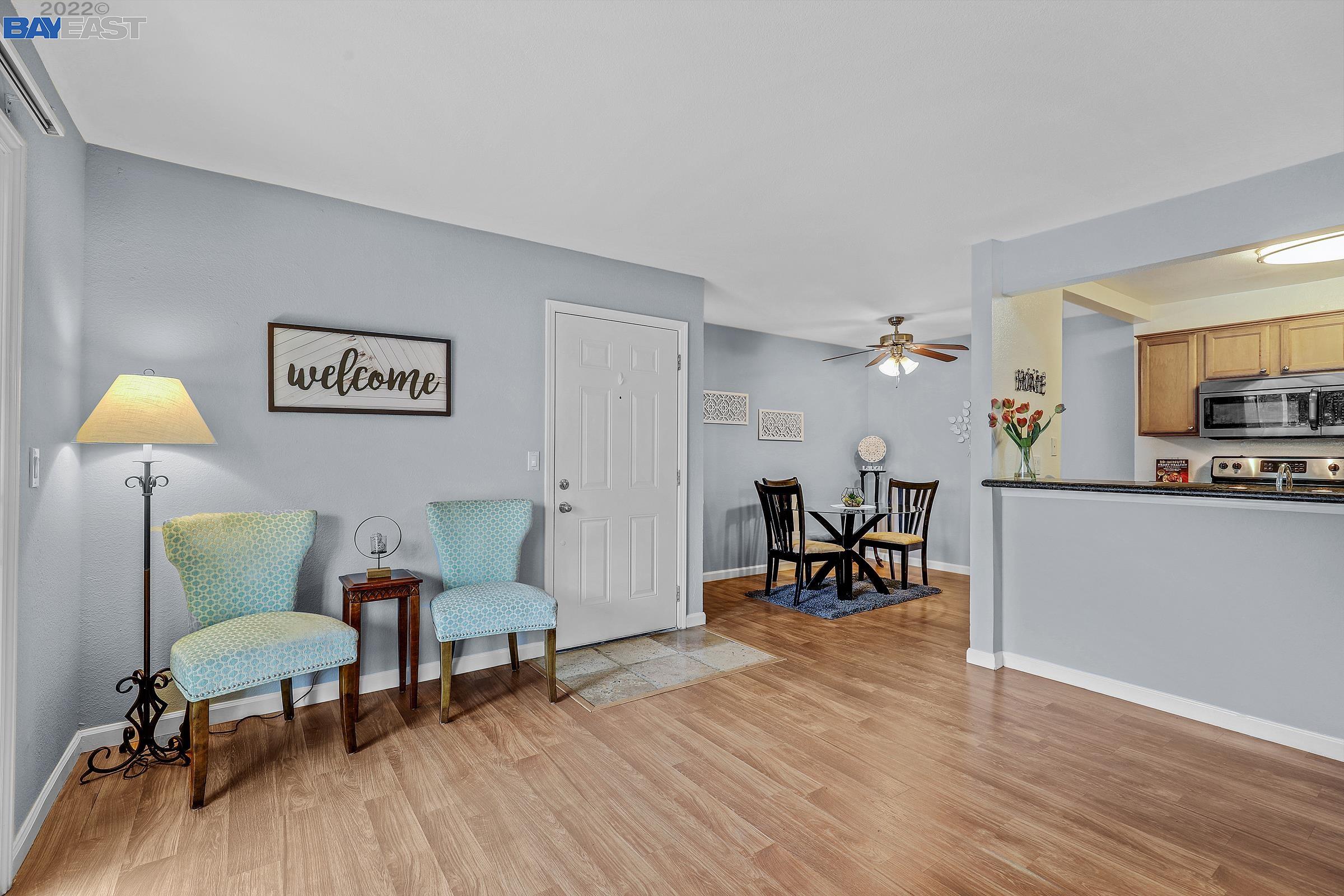a living room with furniture and a dining table with wooden floor