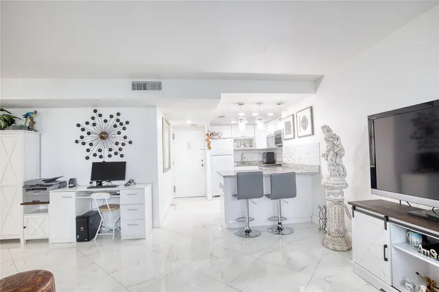 a living room with granite countertop furniture and a flat screen tv