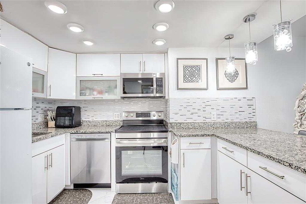 111 Briny Avenue, Unit 2008 Pompano Beach, FL 33062 - Photo 2 of 50 a kitchen with granite countertop white cabinets and white appliances
