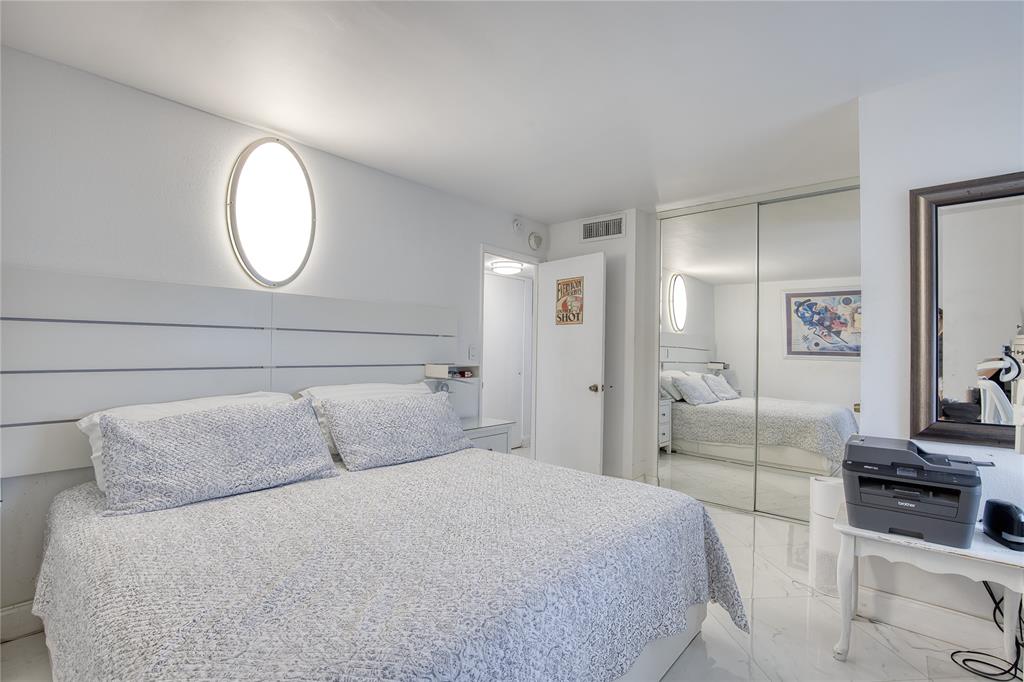 111 Briny Avenue, Unit 2008 Pompano Beach, FL 33062 - Photo 22 of 50 a bedroom with a bed and a mirror