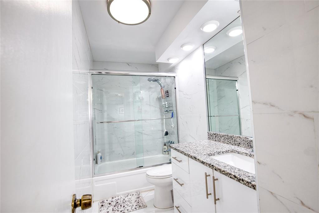 111 Briny Avenue, Unit 2008 Pompano Beach, FL 33062 - Photo 23 of 50 a bathroom with a granite countertop sink a toilet and shower