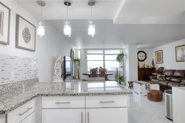 a kitchen with granite countertop cabinets a stove a sink and a granite counter top