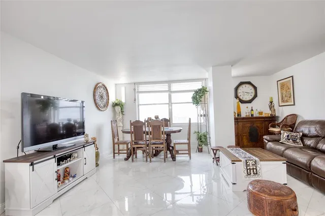 a living room with furniture a flat screen tv and a window