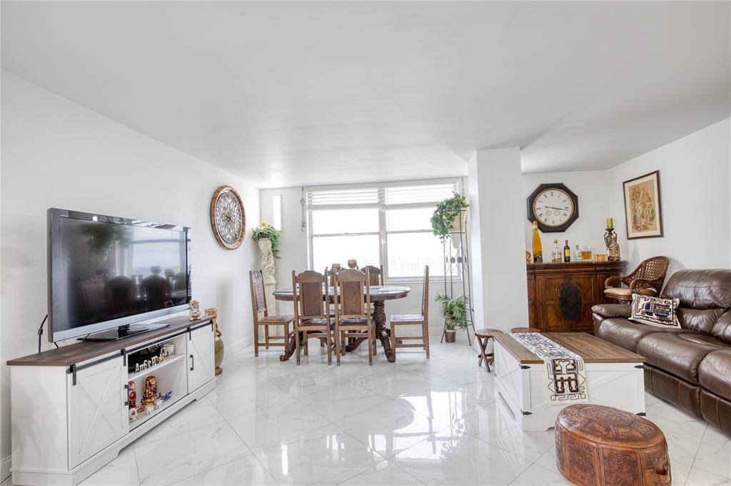111 Briny Avenue, Unit 2008 Pompano Beach, FL 33062 - Photo 9 of 50 a living room with furniture a flat screen tv and a window