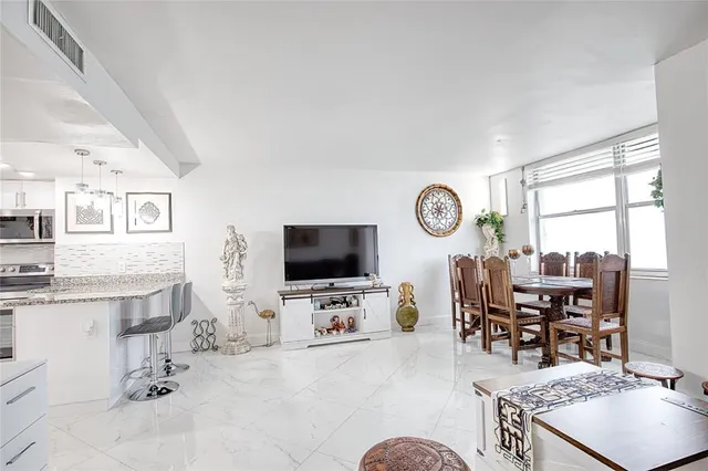a living room with furniture a flat screen tv and a window