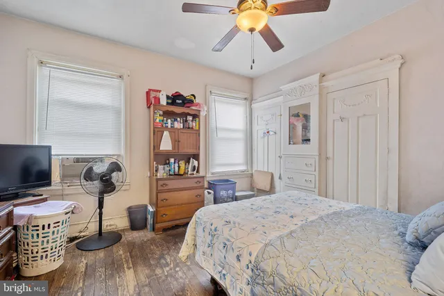 a bedroom with a bed and a flat tv screen on dresser